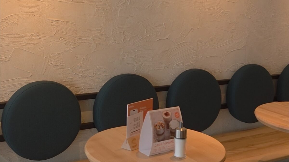 Wie unsere Handgefertigte Terracotta Fliesen und Platten die SZIHN Bäckerei Siebenhirten verwandelt haben Handverputzte Wand mit strukturierter Oberfläche und runden Polsterrückenlehnen im Innenbereich der Szihn Bäckerei