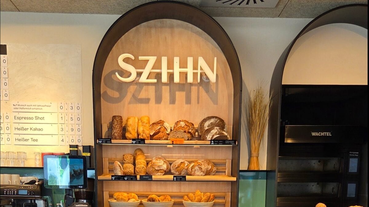 Holzregale mit frischen Broten und dem Szihn-Logo im Hintergrund