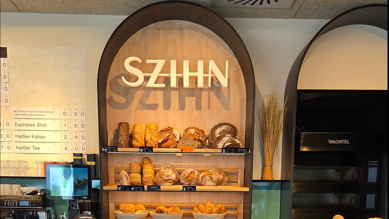 Holzregale mit frischen Broten und dem Szihn-Logo im Hintergrund