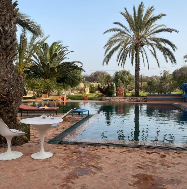 Terracotta Fliesen rund um den Pool – Natürlichkeit, Sicherheit und Stil im Außenbereich Handgefertigte Terracotta Fliesen rund um den Pool in einem mediterranen Garten mit Palmen