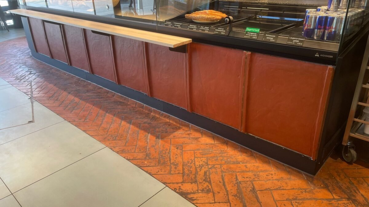 Verkaufstresen der SZIHN Bäckerei Alterla mit handgefertigten Terracotta Platten verkleidet.