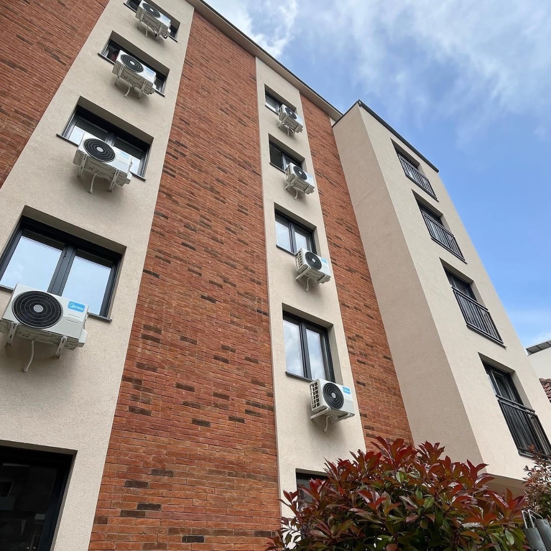 Homepage Mehrstöckiges Gebäude mit Terracotta Fassadenriemchen und moderner Architektur