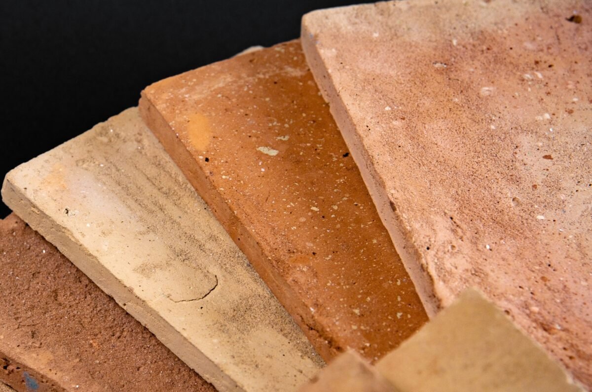 Warme Terracotta Farbnnuancen in handgefertigten Fliesen – Gelb, Ocker und Rot.