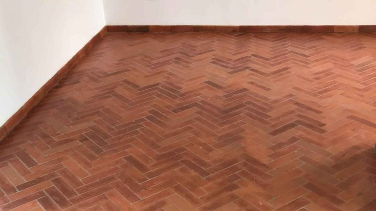 Connections and Transitions in Handcrafted Terracotta Tiles – When Details Decide Architecture Floor–wall connection with handcrafted terracotta tiles laid in a herringbone pattern.